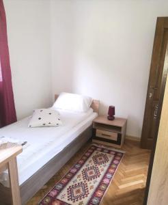 a small bedroom with a bed and a night stand at Pensiunea Costesti in Costeşti