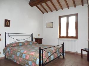 ein Schlafzimmer mit einem Bett in einem weißen Zimmer in der Unterkunft Il Borghetto in Todi
