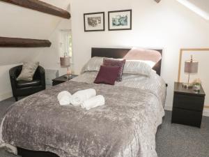 a bedroom with a large bed with towels on it at Maes Elwy in St Asaph
