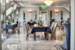 a dining room with tables and chairs and a chandelier at Hotel Biały Dom in Rybnik