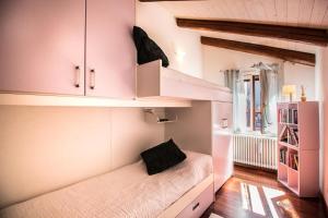 Cette petite chambre comprend un lit avec des armoires roses. dans l'établissement Ca’ Orti, à Venise
