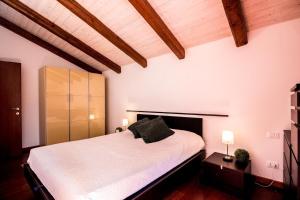 - une chambre avec un grand lit blanc et des plafonds en bois dans l'établissement Ca’ Orti, à Venise