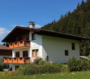 a white house with a balcony on the side of it at Haus Bergquell in Ramsau am Dachstein