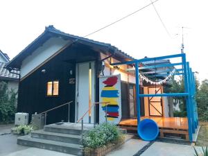 a small black house with a blue door at 民泊大森 in Iyo