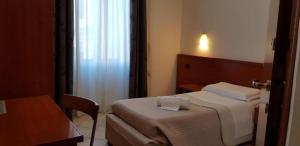A bed or beds in a room at Hotel Luciani