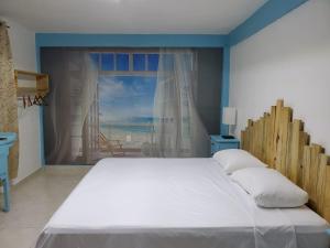 a bedroom with a large bed with a large window at Downtown Hostel Chetumal in Chetumal