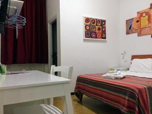 um quarto branco com uma cama e uma mesa e uma mesa e uma mesa; em YooRoom em Palermo