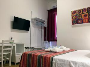 um quarto com uma cama com uma mesa e uma televisão em YooRoom em Palermo