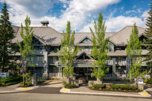 um prédio de apartamentos com árvores em frente em Glacier Lodge em Whistler