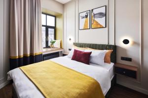 um quarto com uma cama grande e um cobertor amarelo em Kaleidoscope Central em São Petersburgo