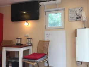a kitchen with a refrigerator and a table and a window at Sportboot Zander in Bornheim