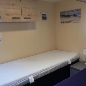 a small bedroom with a bed with white sheets at Sportboot Zander in Bornheim