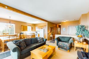 a living room with two couches and a kitchen at Timber Ridge in Big White