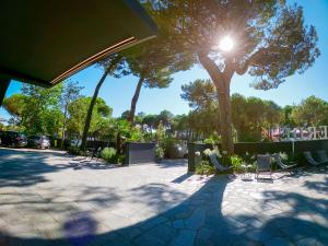 a sun shining through a tree in a park at Hotel Costa Verde in Milano Marittima