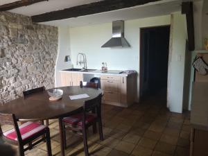 uma cozinha com uma mesa e cadeiras e um lavatório em Maison atypique à Cordes-Sur-Ciel 2 chambres em Cordes-sur-Ciel