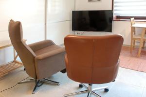 een woonkamer met 2 stoelen en een televisie bij Wo das Ruhrgebiet am schönsten ist in Hattingen