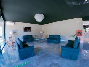 a large living room with blue couches and chairs at Hotel Costa Verde in Milano Marittima