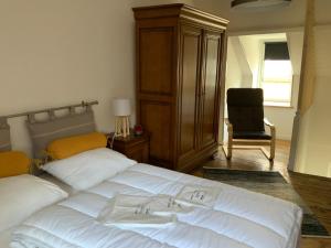 a bedroom with a large white bed and a chair at Villa Georges in Le Tréport