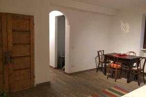 a dining room with a table and chairs and a door at Aubert 64 in Aosta