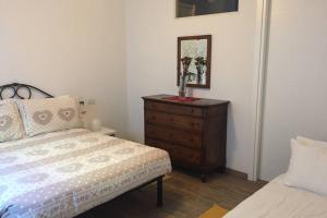 a bedroom with a bed and a dresser with a mirror at Aubert 64 in Aosta