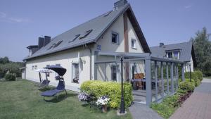 a white house with a roof and a patio at Apartamenty Beata w Sasinie in Sasino