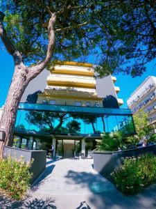 un edificio con un árbol delante de él en Hotel Costa Verde, en Milano Marittima