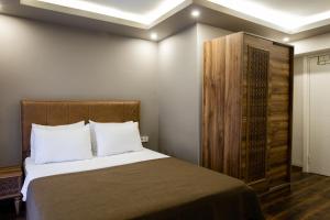 イスタンブールにあるタクシム ムードのベッドルーム1室(ベッド1台付)、木製キャビネットが備わります。