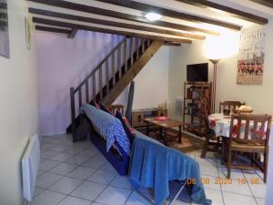 a living room with a staircase and a table at Aux Roses in Vrolle