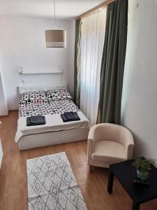Un pequeño dormitorio con una cama y una silla. en Oliwier, en Rewal