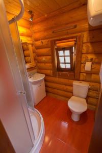 baño con aseo y lavamanos en una cabaña de madera en Ubytovanie Koliba Pacho - Zrub Zuzka en Prievidza
