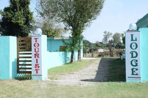 Ein Tor zu einem Haus mit einem Schild, auf dem Sucht steht. in der Unterkunft TOURIST LODGE in Surajpur Jikkla