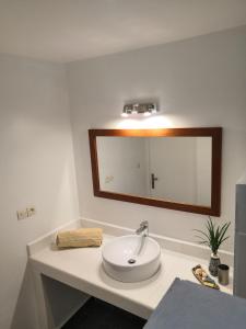 y baño con lavabo blanco y espejo. en Maison d'Hôtes Mandrosoa, en Antananarivo
