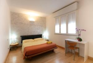 um quarto com uma cama, uma secretária e uma janela em Giardini e Mare em Quartu SantʼElena