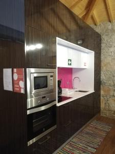 a kitchen with a microwave and a sink at Casa das Bouças in Viana do Castelo