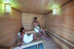 un homme et une femme assis dans un sauna dans l'établissement Cristal Hôtel & Spa, à Cannes