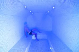 a man sitting on a bench in a swimming pool at Cristal Hôtel & Spa in Cannes