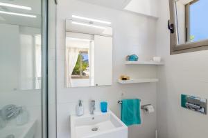 biała łazienka z umywalką i lustrem w obiekcie Modern House With Panoramic Sea View In Mallorca w mieście Son Serra de Marina +31 zdjęć