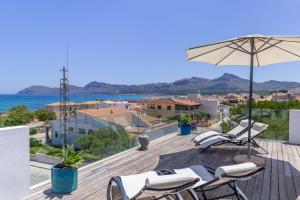 taras z leżakami i parasolem oraz ocean w obiekcie Modern House With Panoramic Sea View In Mallorca w mieście Son Serra de Marina