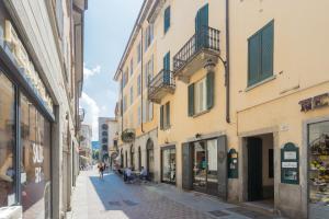 Une rue dans une vieille ville avec des gens assis sur des bancs dans l'établissement Da Pia in Historycal Como City Centre by Rent All Como, à Côme