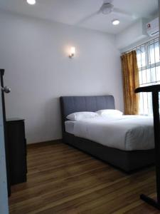 a bedroom with a bed and a wooden floor at Ziehass Homestay D'Perdana Apartment in Kota Bharu