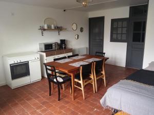 a kitchen and dining room with a table and chairs at Le Manoir de Cocelle in Paris-lʼHôpital