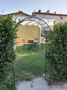 an arbor with a table and chairs in a yard at Il Nido in Lucca