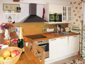 a kitchen with white cabinets and a table with a basket of fruit at Holiday Home Tribbevitz by Interhome in Tribbevitz