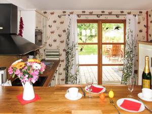 a kitchen with a table with a vase of flowers at Holiday Home Tribbevitz by Interhome in Tribbevitz