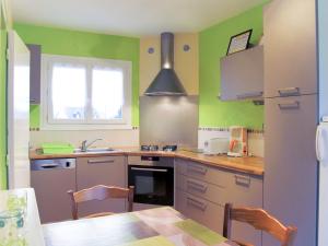 トレガステルにあるHoliday Home Les Cormorans by Interhomeの緑の壁のキッチン、テーブルと椅子