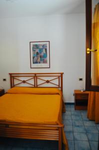 ein Schlafzimmer mit einem gelben Bett und einem Bild an der Wand in der Unterkunft Case Vacanza Vivaldi in Marinella di Selinunte