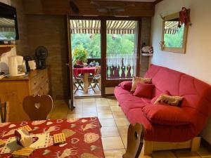 a living room with a red couch and a table at Sallanches 3101 Route de Nant Cruy immeuble le Grand R in Sallanches