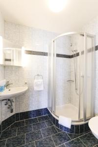 een badkamer met een douche en een wastafel bij hotel löwen in Niederuzwil