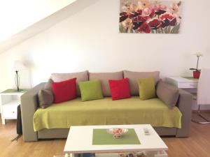 sala de estar con sofá y almohadas coloridas en Apartments Lea, en Cavtat