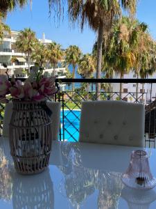 a glass table with a chair and a vase on it at Mi Capricho Apartment with Sea Views and Gardens in La Cala de Mijas +38 photos